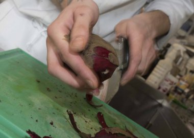 Aşçı, mutfakta bir sopayla pancar soyuyor.