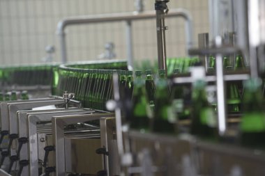 Endüstriyel bir fabrikada yeşil şişelerde maden suyu şişeleme