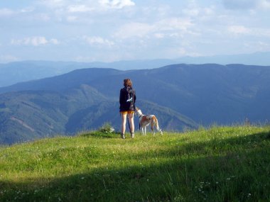 Hayvan sahibi, köpeklerini dağlık arazide yürüyüşe çıkarıyor.