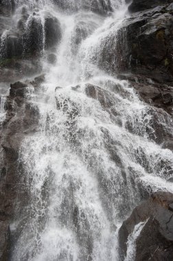 Bir dere ya da nehir yolu, taşlı bir yamaçta şelale.