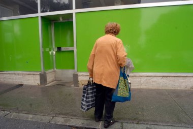 Yalnız yaşlı kadın alışverişini kumaş torbalarla yapıyor.