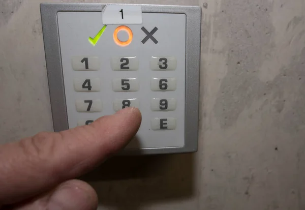 finger putting in a numerical code on a electronic combination lock