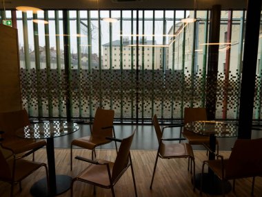 Sandalyeler ve cam masalar, hapishanenin ziyaretçi merkezinde.