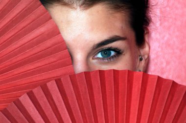 Kırmızı el hayranlarının arkasında bir kadının yüzü, izolasyonun sembolü, insan ruhu.