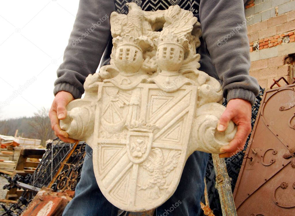 person carrying a medieval stone emblem, symbol for art theft