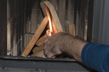 Fayanslı bir sobayı ısıtmak, odunları ısıtmak.