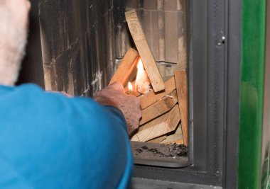 Fayanslı bir sobayı ısıtmak, odunları ısıtmak.