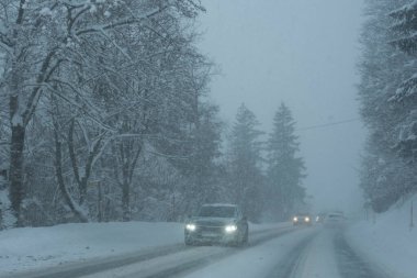Karlı kış yollarında arabalar, köy yolunda trafik.