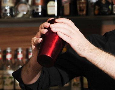 Barmen ya da barmen bir barda içkileri karıştırıyor.