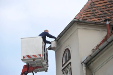 Platformdan bir binanın oluklarının profesyonel olarak temizlenmesi