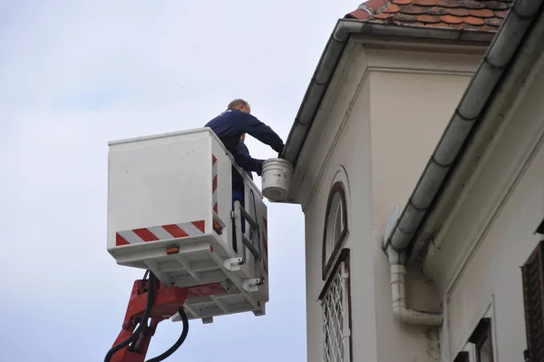 professional cleaning of the gutter of a building from a platform