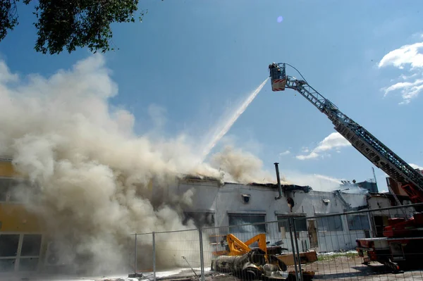 fire department emergency response to a fire with a turntable ladder