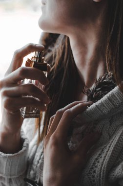 Yakın plan kadın boynuna parfüm serpiyor..