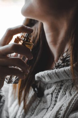 Yakın plan kadın boynuna parfüm serpiyor..