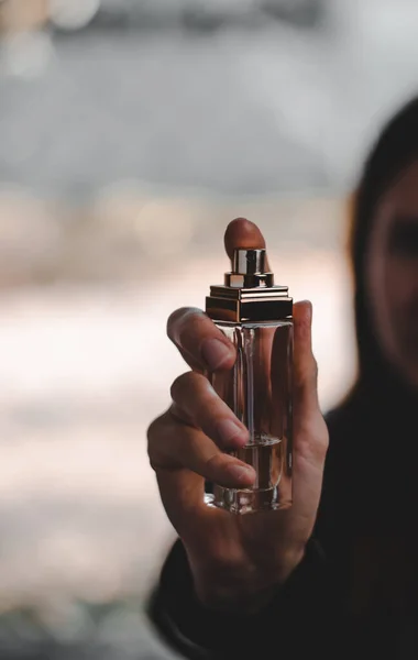 Kobieta Trzymająca Butelkę Perfum Przed Twarzą — Zdjęcie stockowe