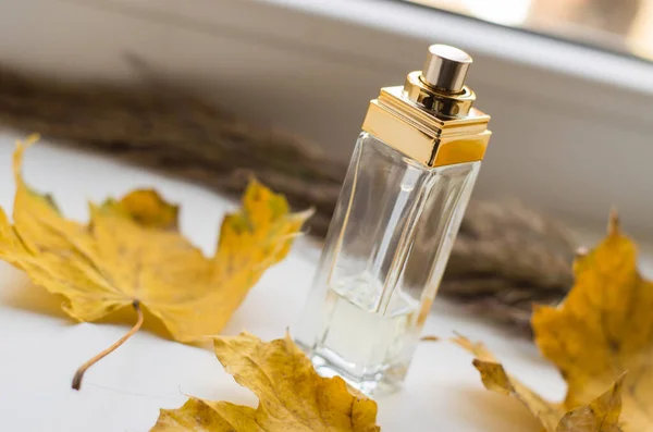 Uma Garrafa Perfume Peitoril Com Folhas Outono Amarelas — Fotografia de Stock