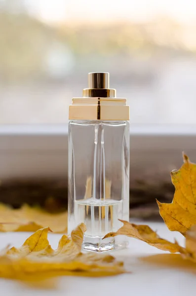 Eine Flasche Parfüm Auf Der Fensterbank Mit Gelben Herbstblättern — Stockfoto
