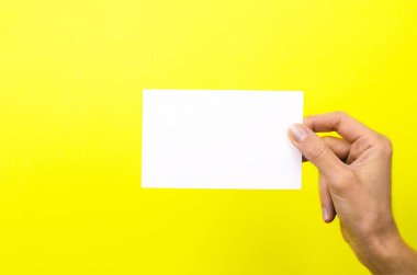 Beyaz kart, sarı arka planda bir kadın elinde.