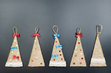 Siyah arka planda kırmızı fiyonklu el yapımı Noel ağaçları