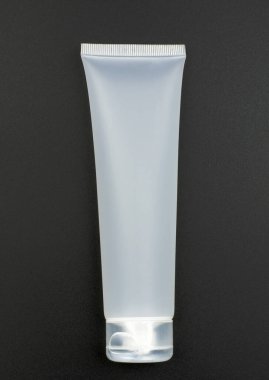 Siyah arka planda krema için beyaz tüp. Doğal organik kozmetik kavramı. Model, üst görünüm