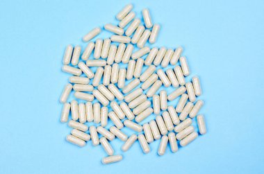 Mavi arkaplan üzerinde birçok beyaz kapsül yakın plan