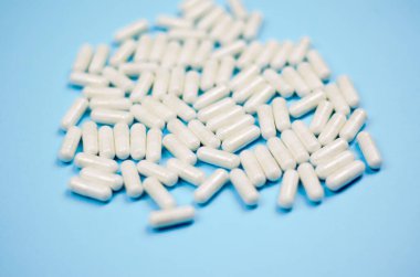 Mavi arkaplan üzerinde birçok beyaz kapsül yakın plan