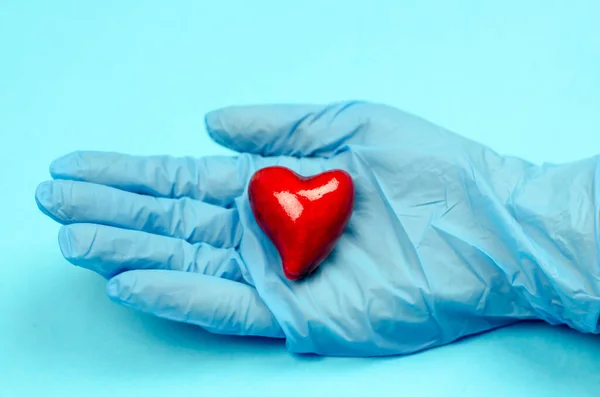 Hände Blauen Medizinhandschuhen Halten Ein Herz Auf Blauem Hintergrund Gesundheitskonzept — Stockfoto