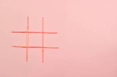 Pembe arka planda pembe plastik içecek pipetlerinin etiket sembolü