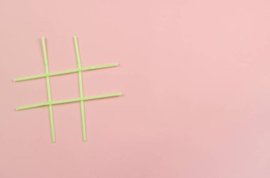 Pembe arka planda yeşil plastik içecek pipetlerinin etiket sembolü