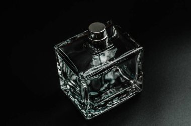 Siyah arka planda bir şişe erkek parfümü, yakın plan.