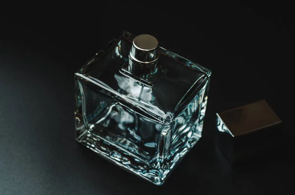 Bottle of men\'s perfume on a black background, close-up