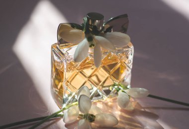 Parlak güneş ışığında bahar çiçekleriyle kadın parfümü