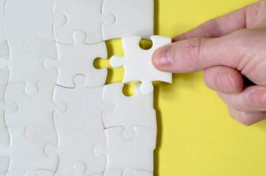 El yapbozun kayıp parçasını yere seriyor. Yapbozun son parçası