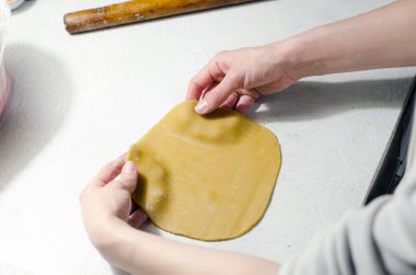 Kadın eli ballı kek için hamuru yuvarlar.