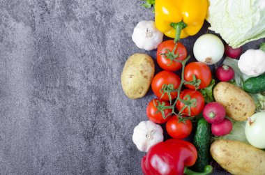 Koyu gri arka planda yazılı taze sebze kompozisyonu. Sebze arka planı.