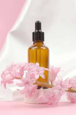 İçinde gerekli yağlar ya da sümbül çiçekleri olan bir serum bulunan kahverengi bir cam şişe. Bakım ve güzellik kavramı