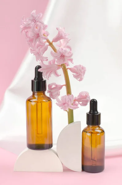 İçinde gerekli yağlar olan iki kahverengi şişe ya da sümbül çiçekli serum. Bakım ve güzellik kavramı