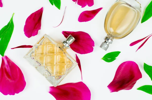 Butelka Kobiecych Perfum Białym Tle Różowymi Płatkami Zielonymi Liśćmi — Zdjęcie stockowe