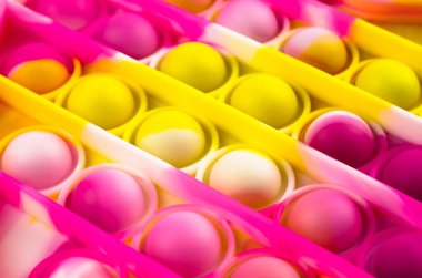 Parlak renkli bir Pop It 'in yakın çekim oyuncağı. Güzel motor becerileri geliştirmek için çocuk oyuncağı.