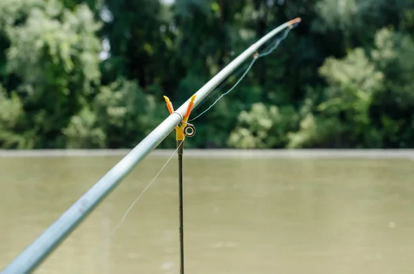 Fishing rod on a stand by the river. Active recreation and fishing concept