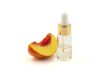Yağ ya da serum içeren bir şişe ve beyaz arka planda taze şeftali dilimi.