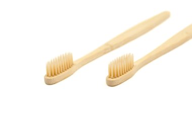 Beyaz arka planda seçici odaklı iki tahta diş fırçası. Çevre dostu bambu diş fırçaları.