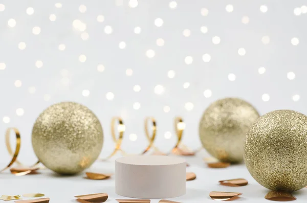 化粧品を紹介するクリスマスシーン 白いお祝いの背景に製品デモのためのベージュの台座 黄金のボール コンフェッティ ガーランドライト付きの新年の装飾の表彰台 — ストック写真
