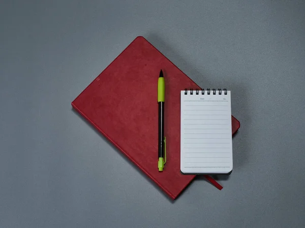 Red organizer, small notepad and mechanical pencil.