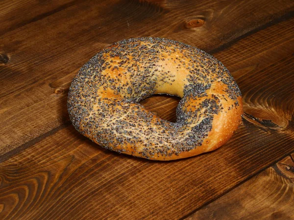 Färsk Bagel Med Vallmofrön Ett Mörkt Träbord — Stockfoto