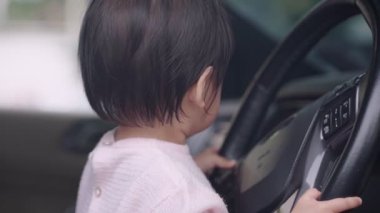 Araba şoförü koltuğunda oturan tatlı Asyalı kadın sürücü direksiyon simidi, çocukluk anıları ve merakı, mutlu ve neşeli çocuk öğrenme becerileri, saf ve masum kız.