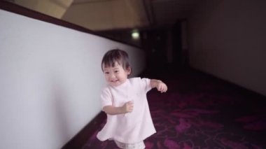 Asyalı bebek kameraya bakıp eğleniyor, çılgın küçük kız gülüyor, çocuk gelişimi becerisi, saf masumiyet, sağlıklı mutlu komik Asyalı çocuklar ağır çekimde gülümsüyor, çocuk ve sorumluluk yetiştiriyor, öğrenme yeteneği kazanıyor.