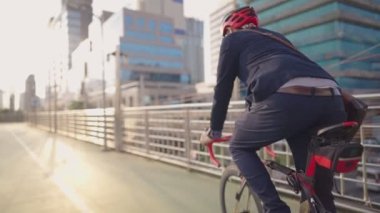 Mutlu genç kurye bisiklet sürmeye başladı müşteriler ve müşteriler için sipariş vermek üzere bisiklet yolu üzerinde, modern şehirde güneşli bir gün şık şehir binaları, bisiklet severler, favori hobi adaptasyonu, çevre koruma veya sorunları ile