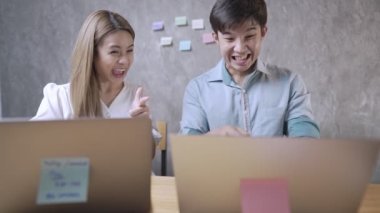 İyi bir şeyin sinyalini gösteren iki mutlu arkadaş, karışık ırk öğrencileri, bilgisayar üzerinde çalışan Asyalı genç öğrenciler, üniversite başvurusu veya istihdam teklifi almak, kablosuz internet bağlantısı, kazançlı ofis becerileri