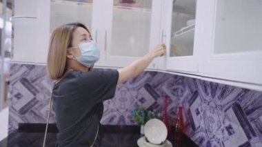 Yüzü maskeli sarışın kız emlak mutfak galerisi, pürüzsüz beyaz tenli kadın elleri cam kapılı mutfak dolabını açıyor, arkadaşının evini ziyaret ederken temiz bulaşık takımı arıyor, mobilya üretimi, pazarlama yarışması fiyatı